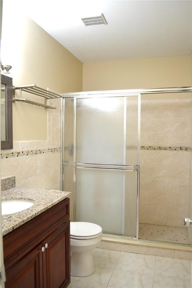 full bath featuring visible vents, toilet, marble finish floor, vanity, and a shower stall