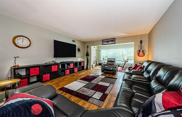 living room featuring a textured ceiling, wood finished floors, and visible vents