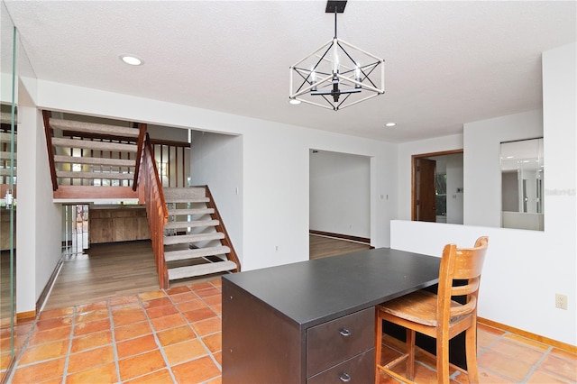 tiled dining area featuring an inviting chandelier and a textured ceiling