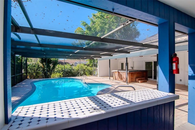 view of swimming pool with a lanai, exterior bar, a hot tub, and a patio