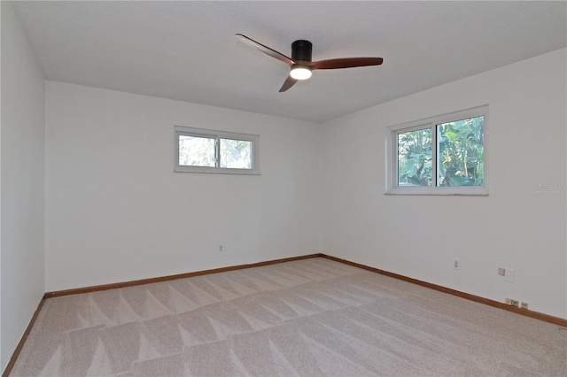 unfurnished room featuring light carpet and ceiling fan