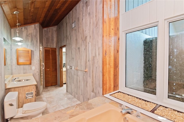 bathroom with toilet, wooden walls, wooden ceiling, a tub to relax in, and vanity