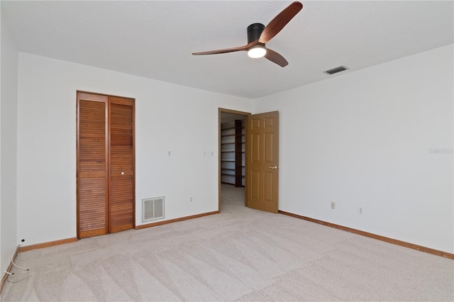 unfurnished bedroom with light carpet, ceiling fan, and a closet