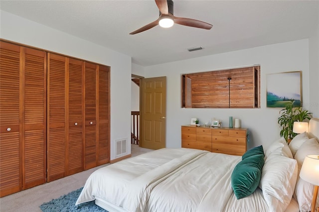 bedroom featuring ceiling fan, a closet, a textured ceiling, and carpet flooring