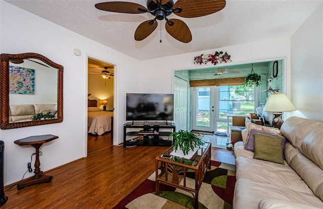 living room with french doors, a textured ceiling, and hardwood / wood-style flooring