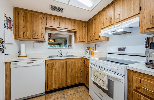 kitchen featuring light tile patterned floors, white appliances, and sink