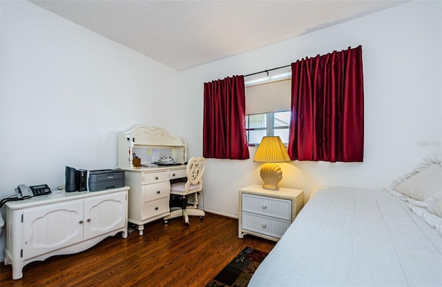 bedroom featuring a textured ceiling and dark hardwood / wood-style flooring