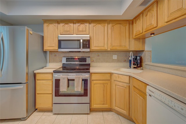 kitchen with tasteful backsplash, stainless steel appliances, sink, light tile patterned floors, and light brown cabinets