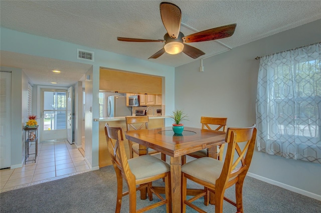 tiled dining space featuring ceiling fan and a textured ceiling