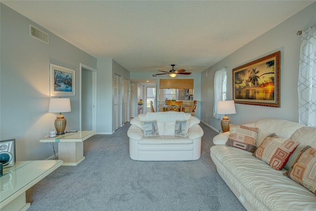 carpeted living room with ceiling fan