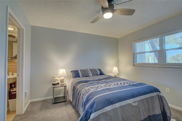 bedroom featuring a textured ceiling, light colored carpet, and ceiling fan