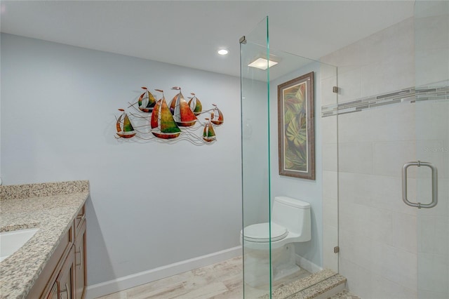 bathroom featuring toilet, a shower with door, vanity, and hardwood / wood-style flooring