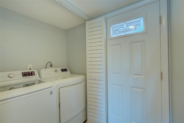 laundry area with independent washer and dryer and a textured ceiling