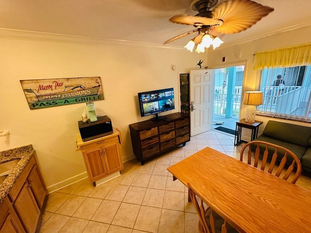 tiled dining area featuring ornamental molding and ceiling fan