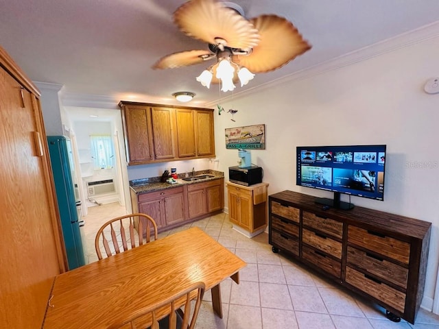 tiled dining area featuring sink, ceiling fan, and crown molding