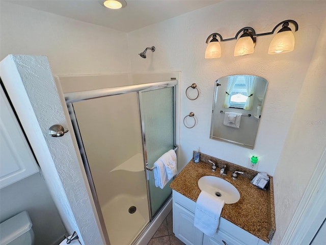 bathroom featuring walk in shower, vanity, toilet, and tile floors