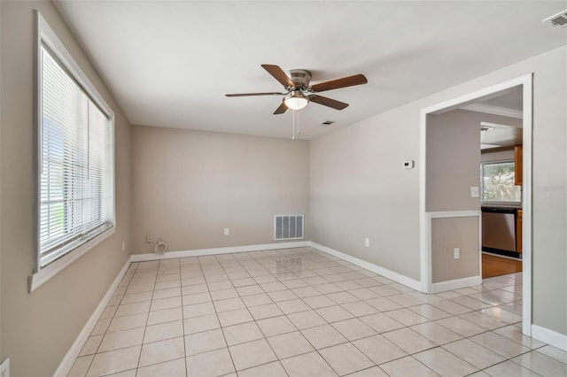 tiled spare room featuring ceiling fan and a healthy amount of sunlight