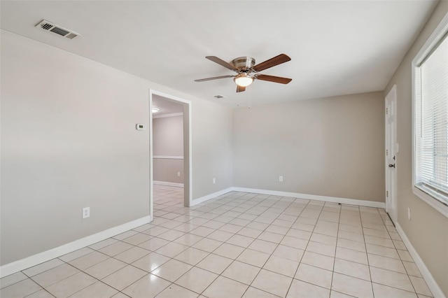 empty room with ceiling fan and light tile patterned floors