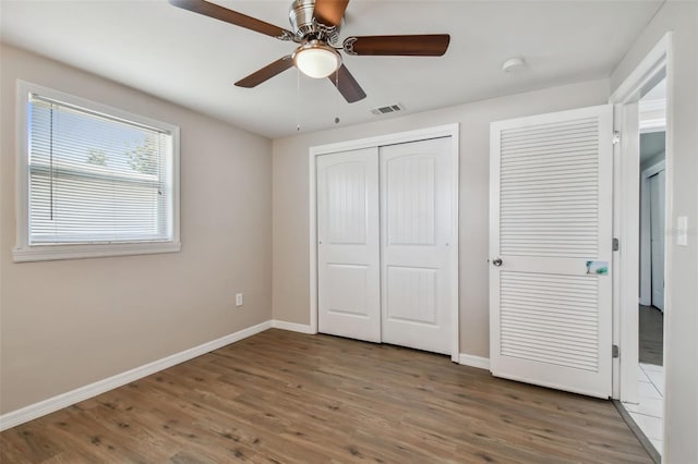 unfurnished bedroom with dark hardwood / wood-style floors and ceiling fan