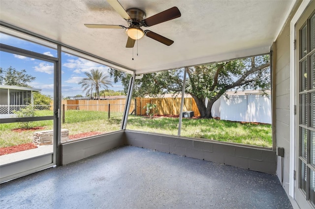 unfurnished sunroom featuring ceiling fan