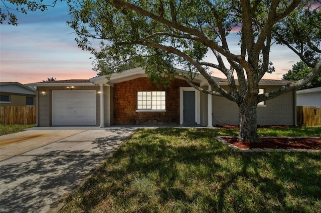 ranch-style home featuring a lawn and a garage