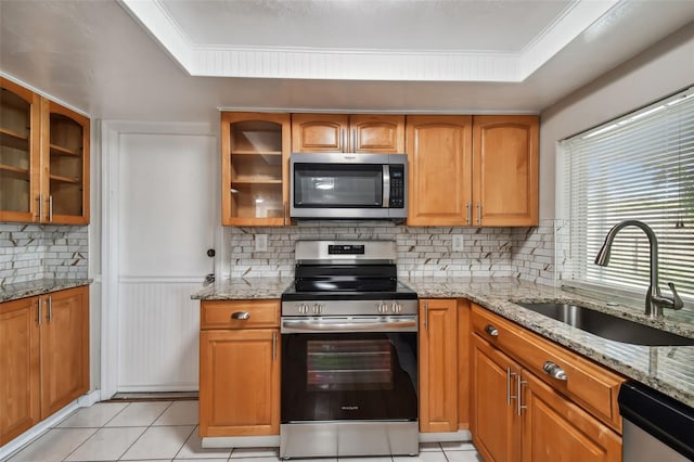 kitchen with light stone counters, sink, and stainless steel appliances