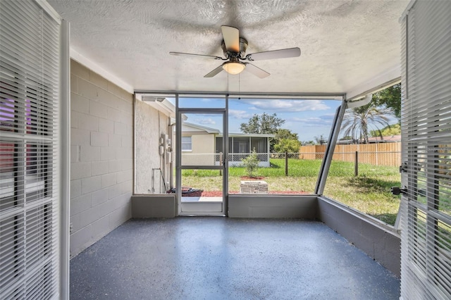 unfurnished sunroom featuring ceiling fan