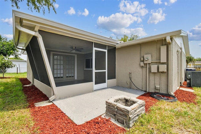 back of house with a patio, an outdoor fire pit, cooling unit, and a sunroom