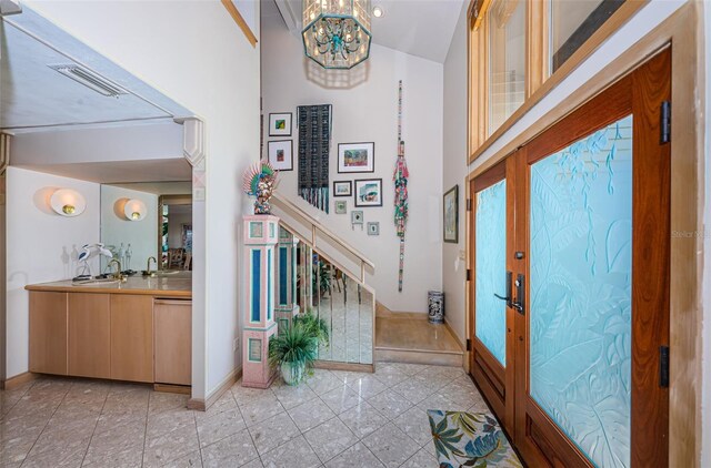 entrance foyer with sink, light tile floors, and an inviting chandelier