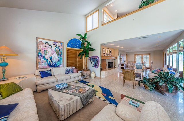 tiled living room featuring a towering ceiling and a tile fireplace