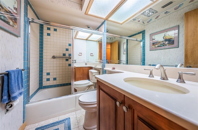 full bathroom with tile flooring, shower / bath combination with glass door, toilet, and vanity with extensive cabinet space