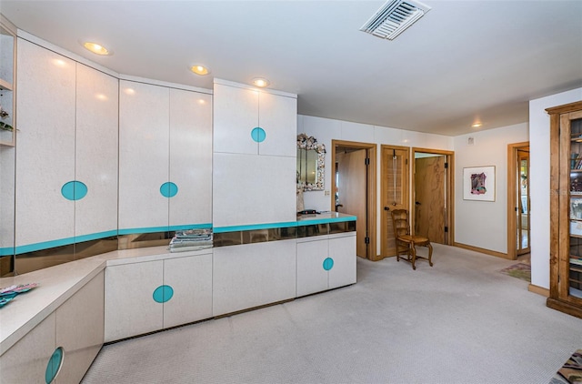 interior space featuring light carpet and white cabinetry