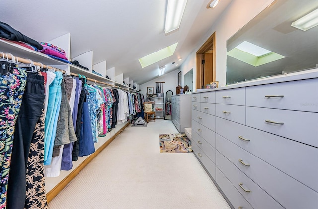 walk in closet with light colored carpet and vaulted ceiling with skylight