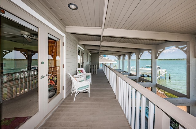 exterior space featuring beam ceiling, a wealth of natural light, ceiling fan, and a water view