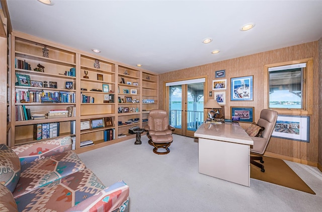 office space with built in shelves, light colored carpet, and french doors