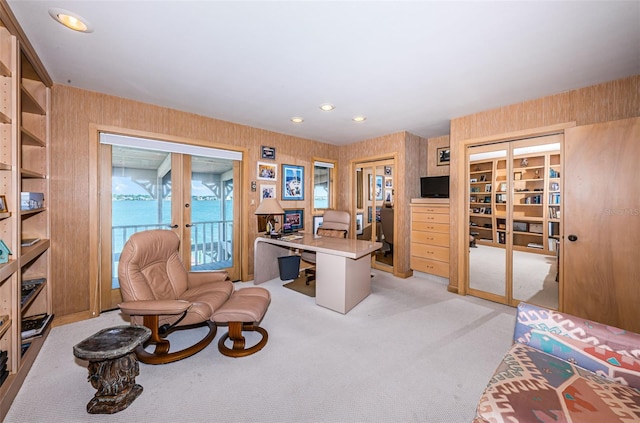 office area with light colored carpet, wooden walls, and french doors