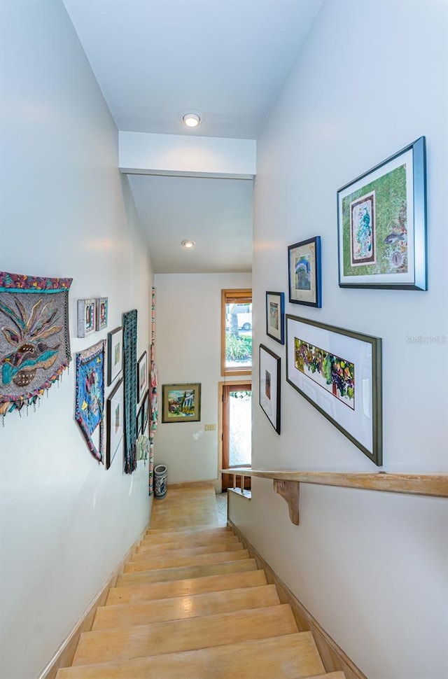 stairway with light hardwood / wood-style floors