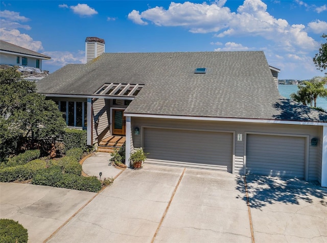 view of front of house featuring concrete driveway, roof with shingles, and an attached garage