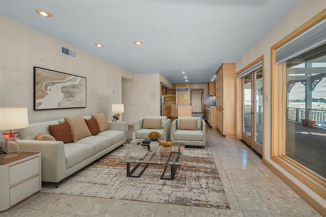 living room with light tile patterned floors, visible vents, and recessed lighting