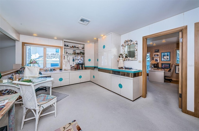 kitchen featuring light carpet, white cabinets, visible vents, and open shelves