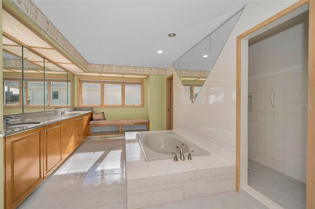 bathroom featuring a garden tub, walk in shower, tile patterned flooring, and a sink