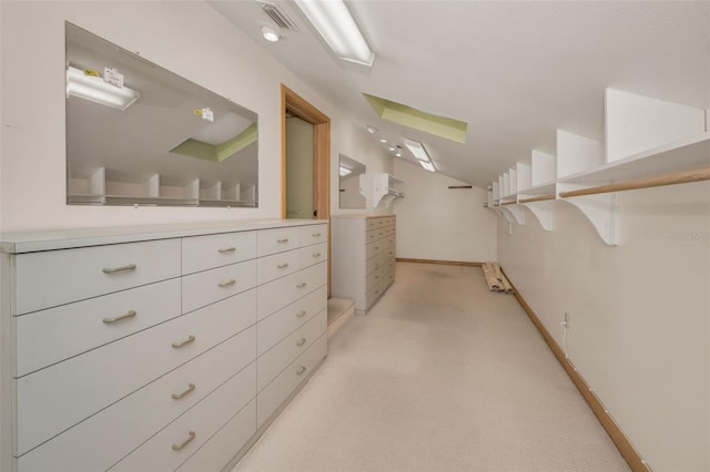 walk in closet featuring lofted ceiling and light carpet