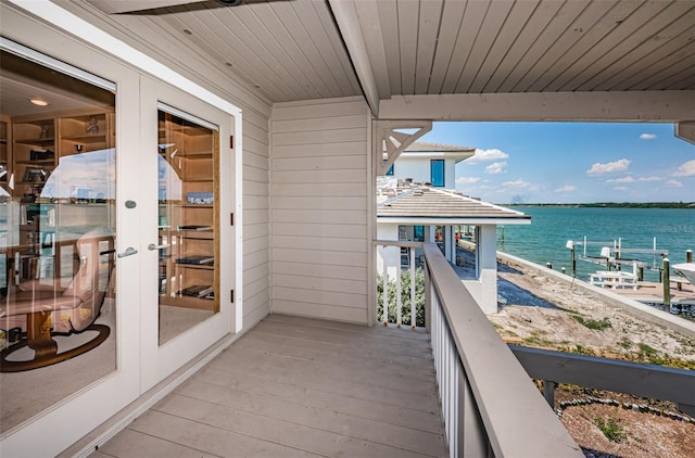 balcony with a water view and french doors