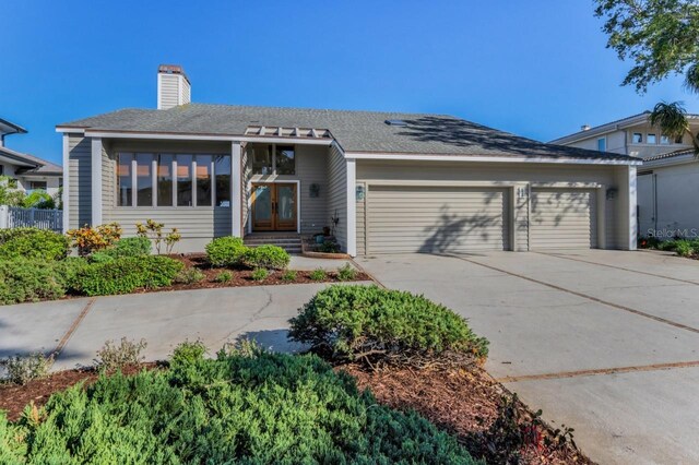 526 Belle Isle Ave, Belleair Beach, FL 33786 - view of front of house featuring concrete driveway, a chimney, and a garage
