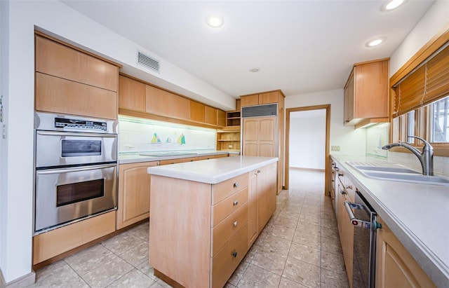 526 Belle Isle Ave, Belleair Beach, FL 33786 - kitchen with a center island, a sink, light brown cabinetry, light countertops, and appliances with stainless steel finishes