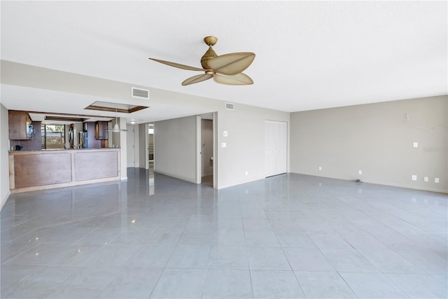 spare room with ceiling fan and light tile patterned flooring