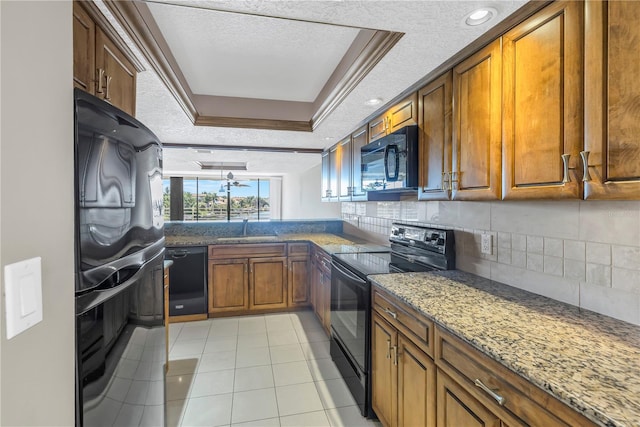 kitchen featuring a raised ceiling, sink, black appliances, and a textured ceiling