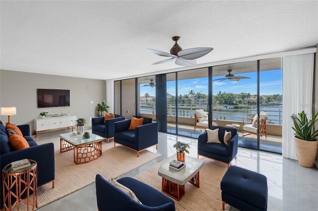 living room featuring floor to ceiling windows, a water view, and a textured ceiling