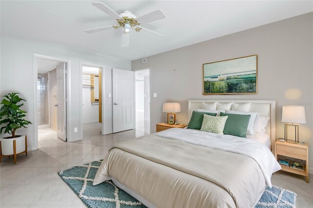 tiled bedroom featuring connected bathroom, a spacious closet, and ceiling fan