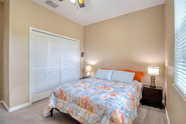 bedroom with light carpet, a closet, and ceiling fan